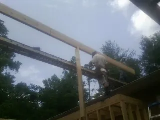 Carpenter setting a ridge beam over a new addition frame — Ice Dam Removal by Roofing Brothers in Teasdale