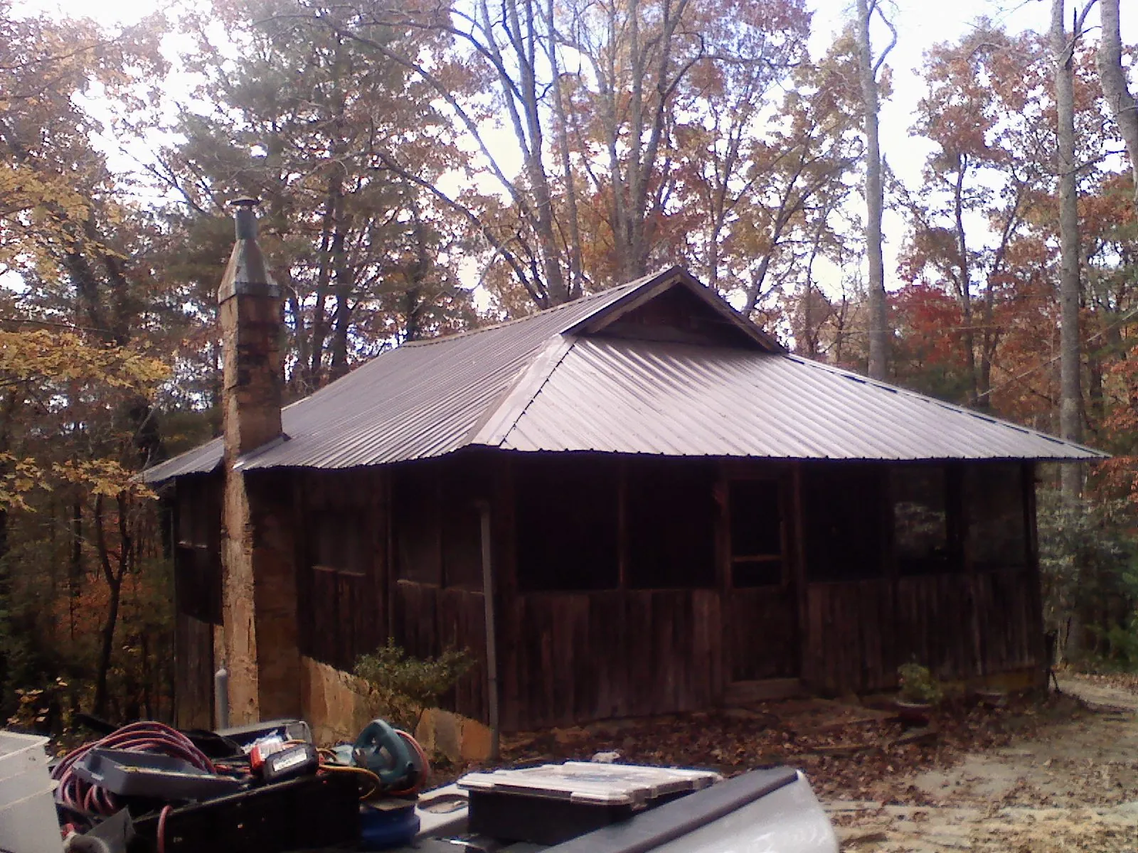Brown metal hip roof on an old cabin with a stone chimney in Teasdale