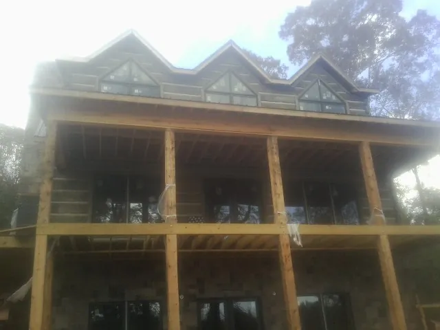 Dormers and porch framing on a large log home under construction — Roof Coating work by our crew in Teasdale