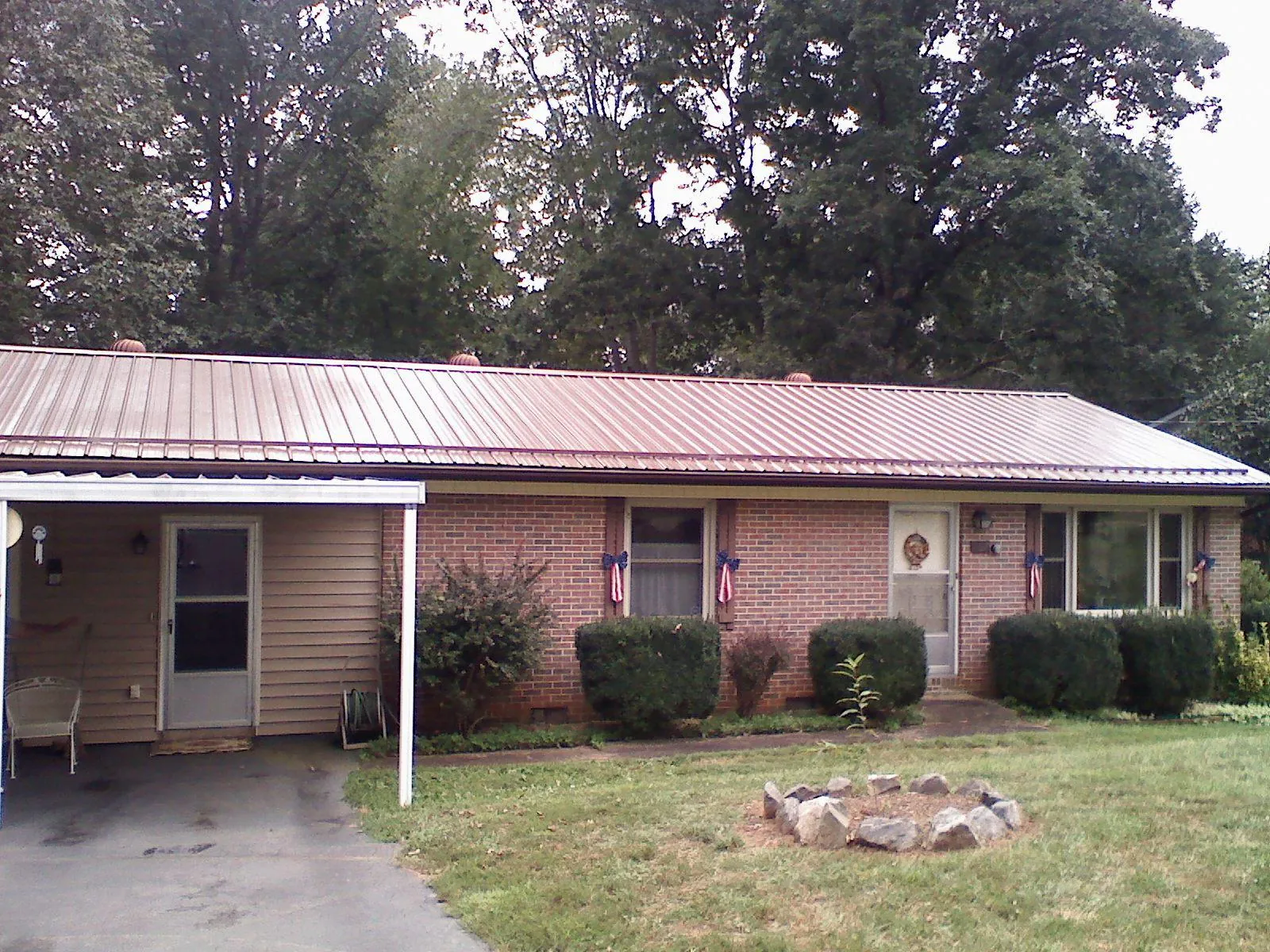 Bronze metal roof and carport on a brick ranch home — Roof Repair work by our crew in Teasdale